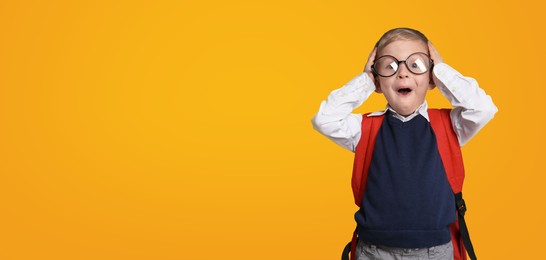 First time at school. Funny little child wearing glasses on yellow background, space for text. Banner design