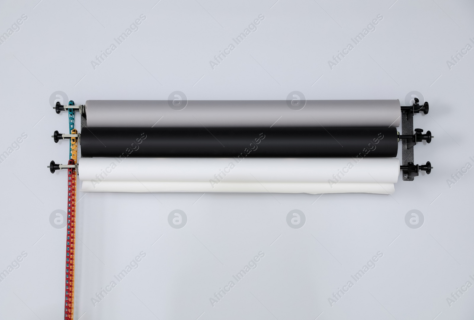 Photo of Colorful photo background rolls on white wall in studio