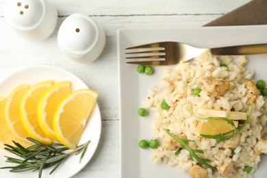 Photo of Delicious chicken risotto served on white wooden table, flat lay