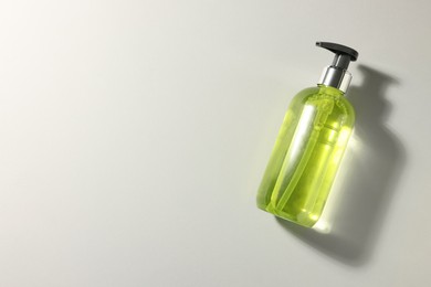 Photo of Bottle of liquid soap on grey background, top view. Space for text