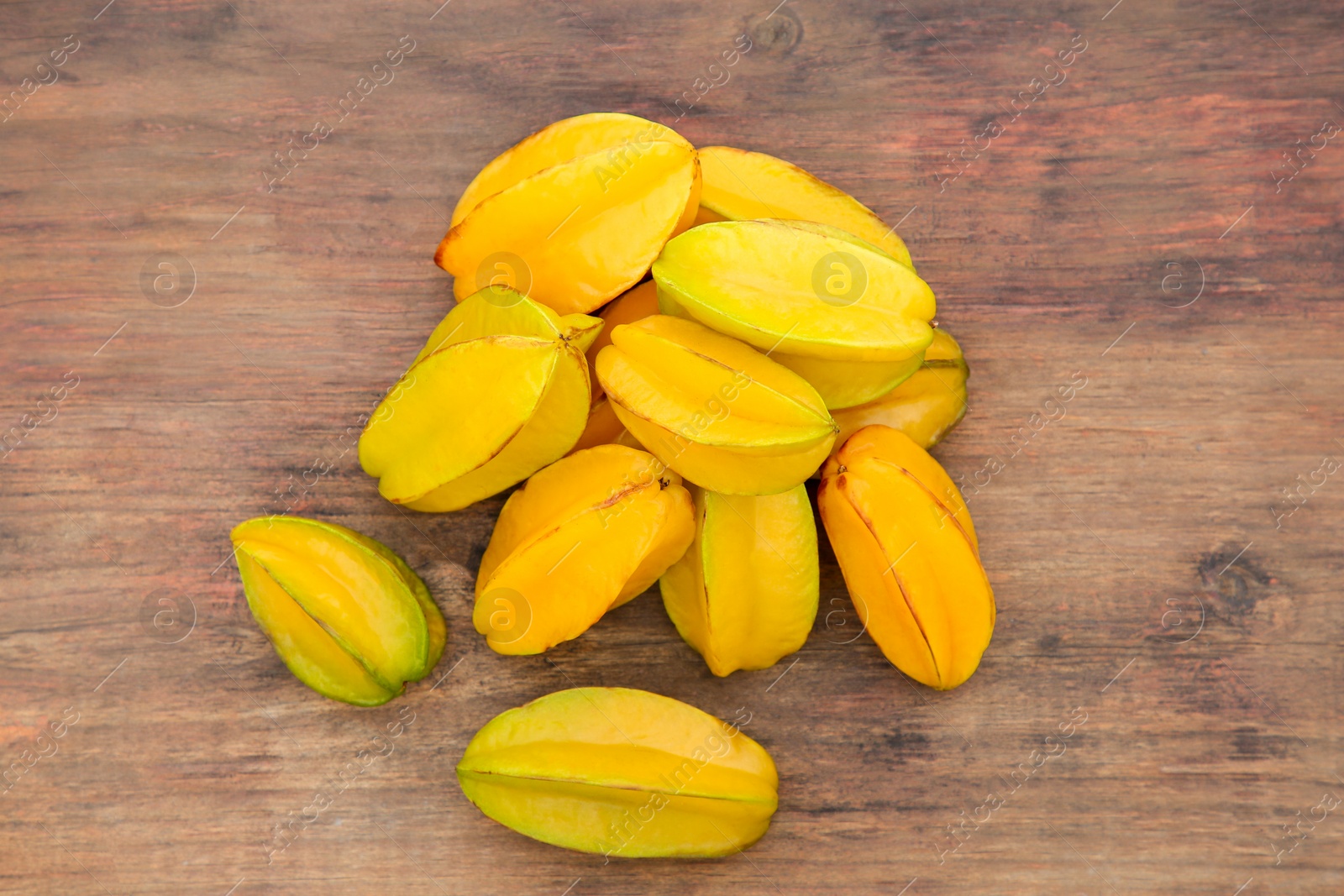 Photo of Delicious ripe carambolas on wooden table, flat lay