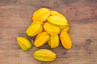 Delicious ripe carambolas on wooden table, flat lay