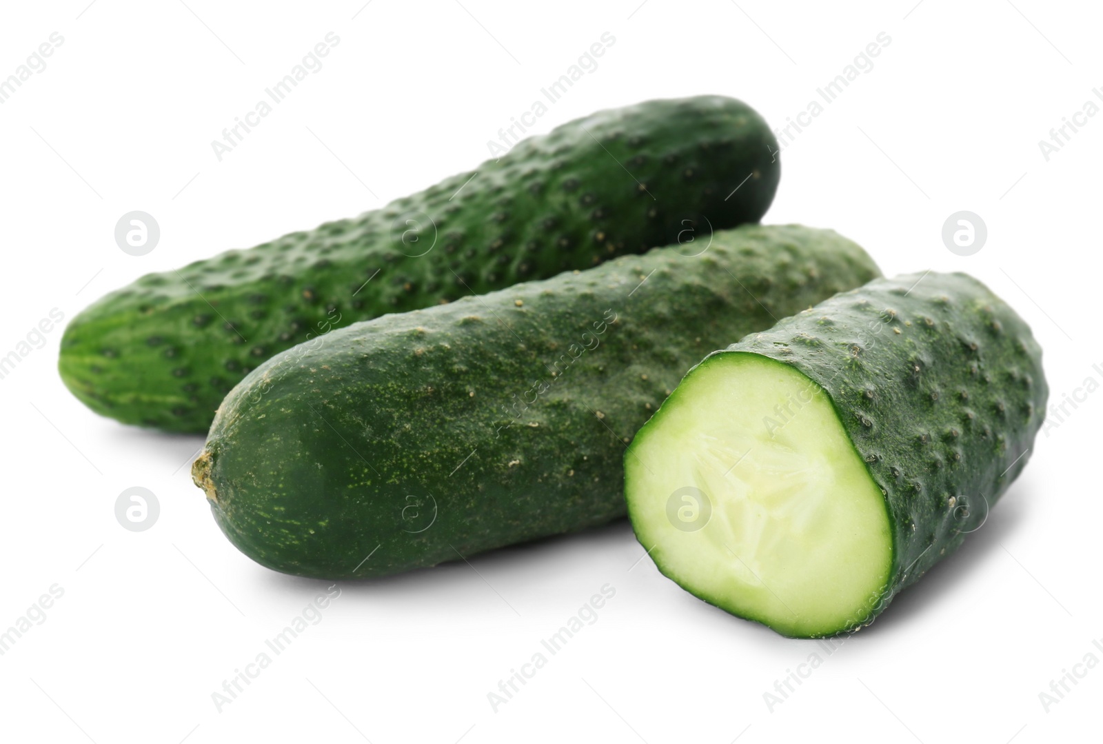 Photo of Whole and cut cucumbers on white background