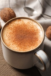 Delicious eggnog with cinnamon on wooden table, closeup