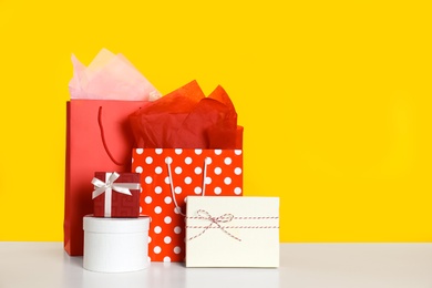 Photo of Shopping bags and gift boxes on yellow background. Space for text