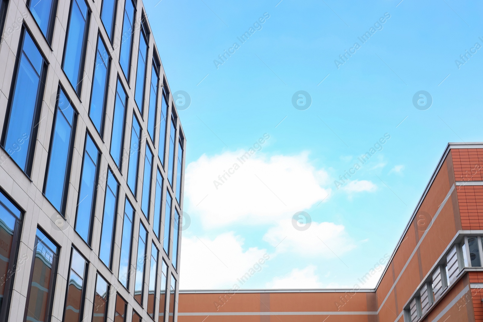 Photo of Modern buildings against blue sky, low angle view. space for text