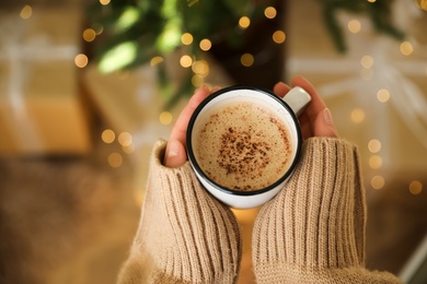 Photo of Woman holding cup of cocoa indoors, top view. Christmas mood