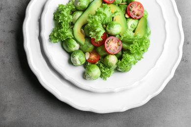 Photo of Tasty salad with Brussels sprouts on grey table, top view