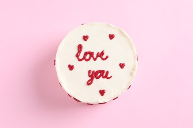 Photo of Bento cake with text Love You on pink table, top view. St. Valentine's day surprise