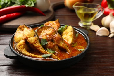 Photo of Tasty fish curry on wooden table, closeup. Indian cuisine