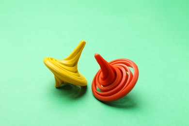 Yellow and orange spinning tops on green background