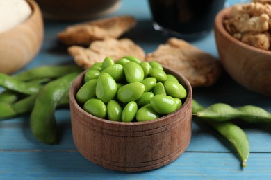 Photo of Fresh green soy beans and other organic products on light blue wooden table, closeup