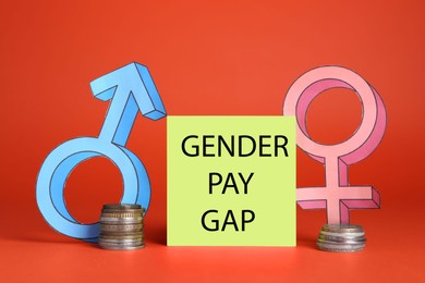 Photo of Gender pay gap. Male and female symbols near paper note, stacked coins against red background