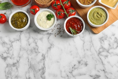 Flat lay composition with different sauces and space for text on marble background