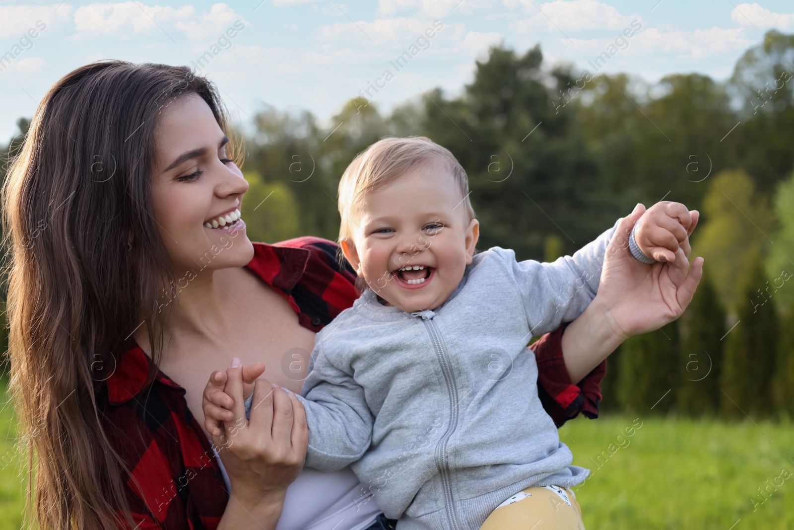 Photo of Happy mother with her cute baby in park on sunny day