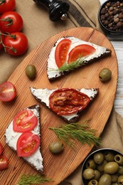 Photo of Delicious bruschettas with ricotta cheese, dill, olives, fresh and sun dried tomatoes on table, flat lay