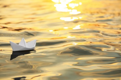 Paper boat floating on water outdoors. Space for text