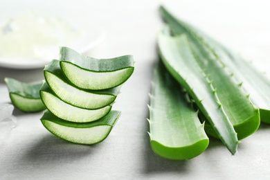 Fresh sliced aloe vera leaves on light background