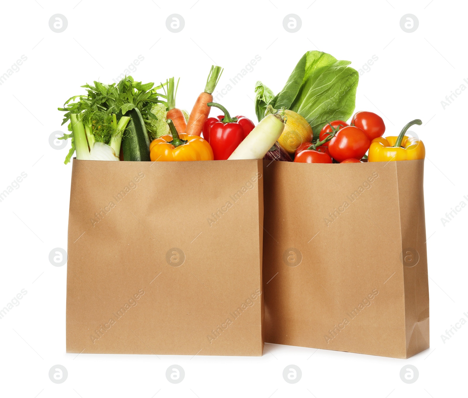 Photo of Paper bags with fresh vegetables on white background