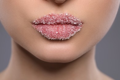 Woman with beautiful lips covered in sugar on background, closeup