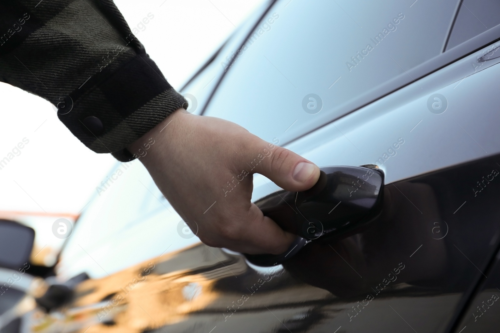 Photo of Closeup view of man opening car door outdoors