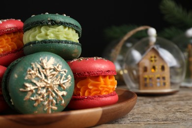 Photo of Beautifully decorated Christmas macarons and festive decor on wooden table, closeup