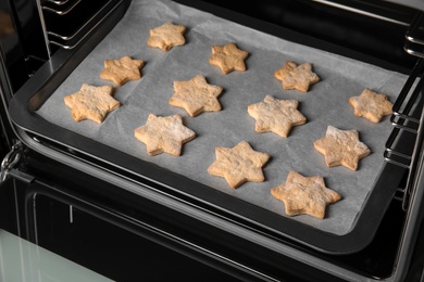 Baking tray with tasty Christmas cookies in oven