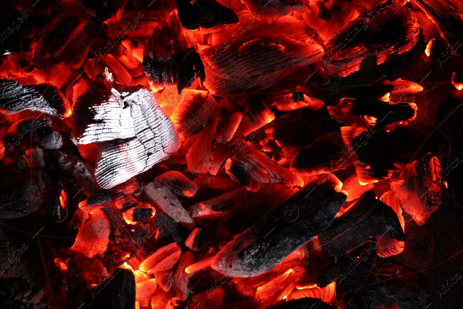 Photo of Pieces of hot smoldering coal as background, top view