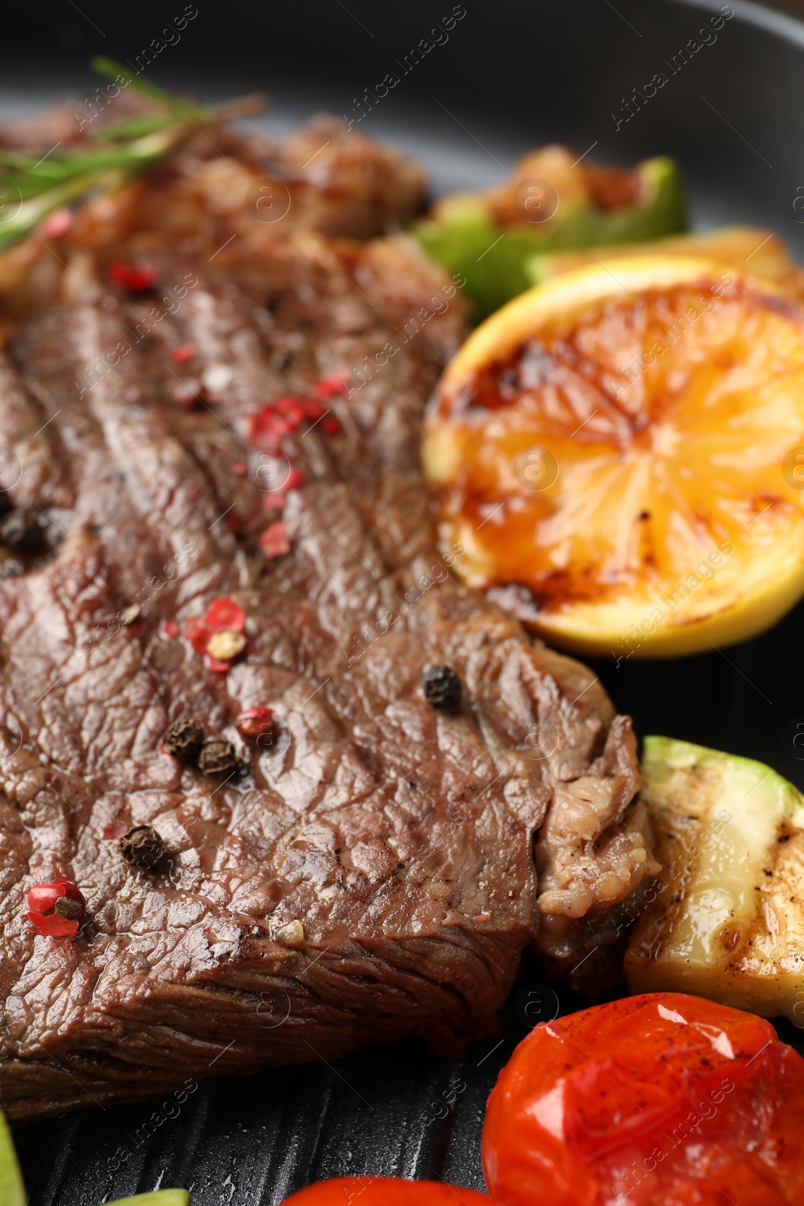 Photo of Delicious grilled beef steak and vegetables in frying pan, closeup