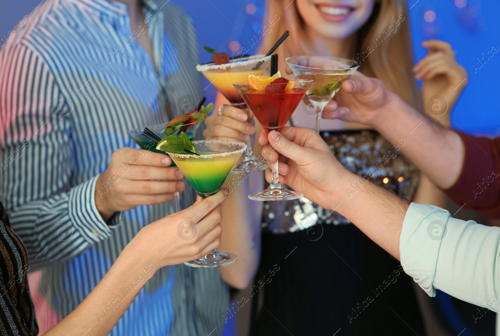 Photo of Group of young people holding martini cocktails at party, closeup