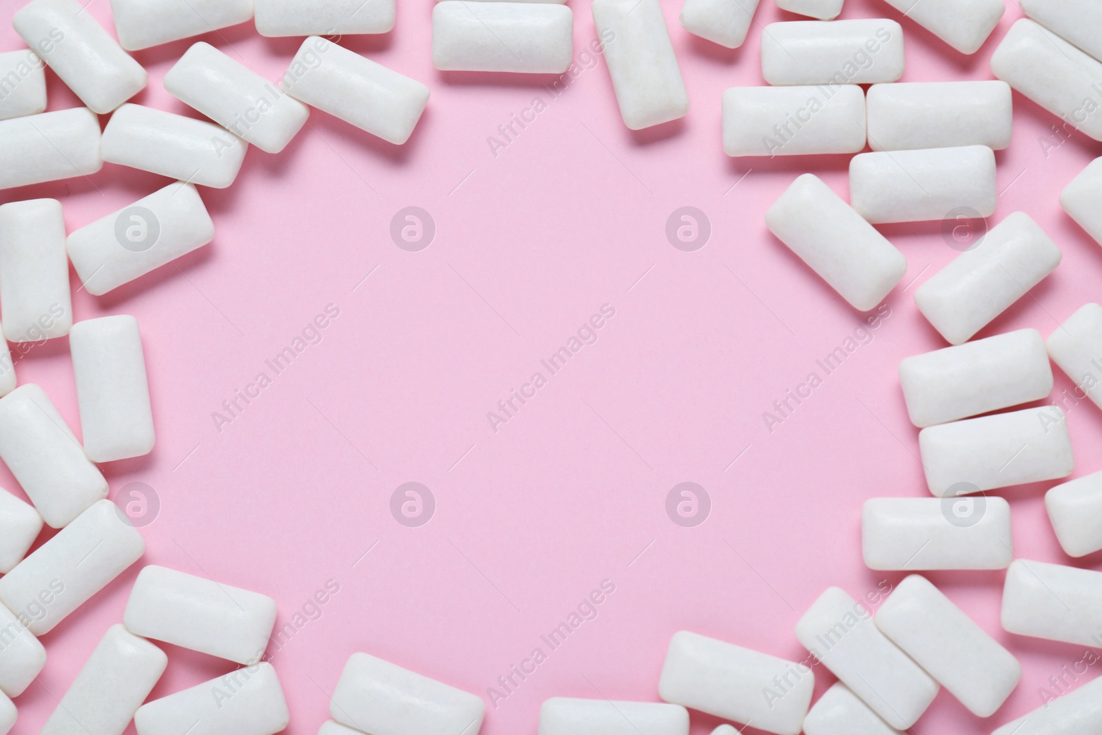 Photo of Frame made of white chewing gums on pale pink background, flat lay. Space for text