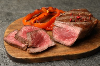 Photo of Delicious grilled beef steak with spices on gray table, closeup