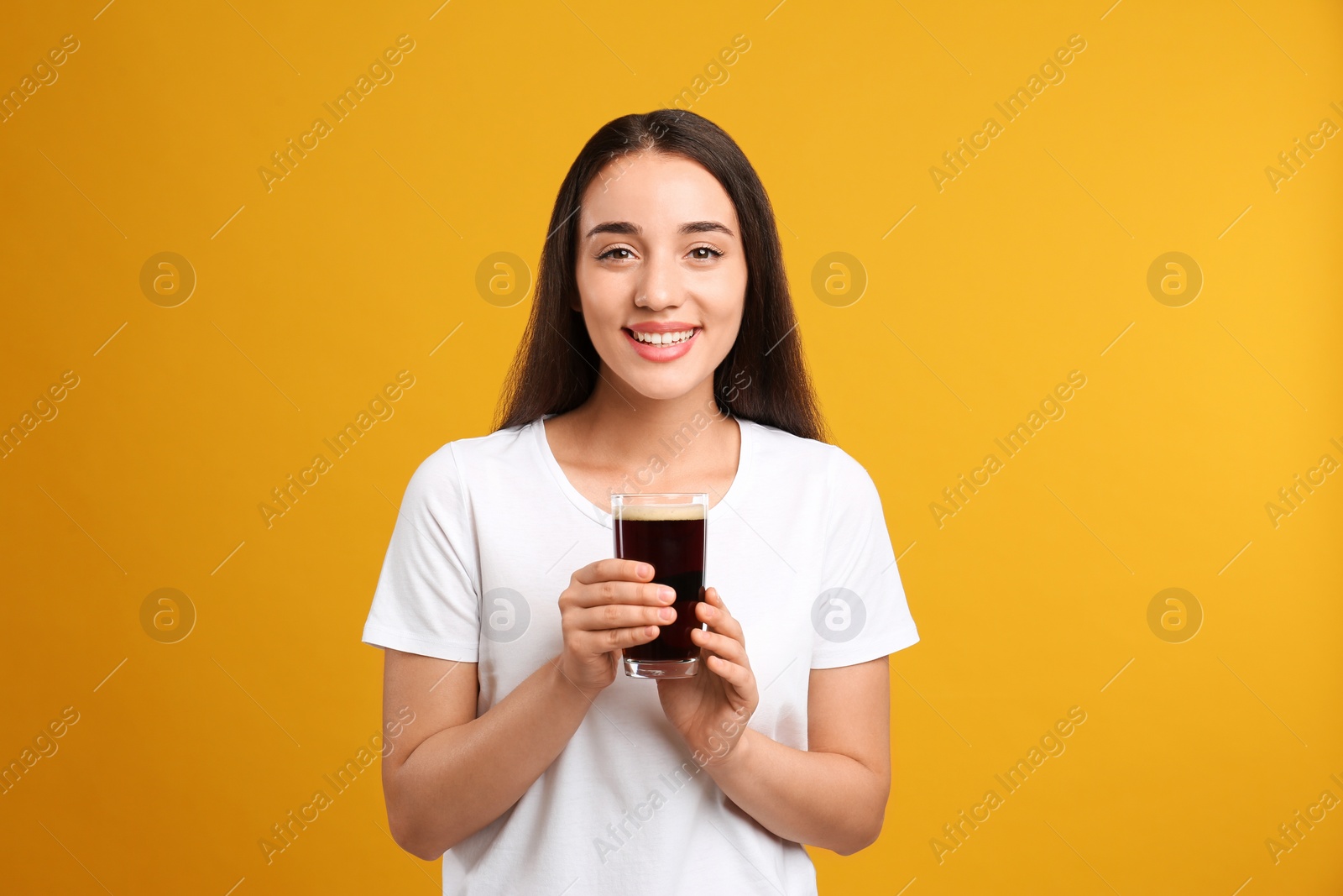 Photo of Beautiful woman with cold kvass on yellow background. Traditional Russian summer drink