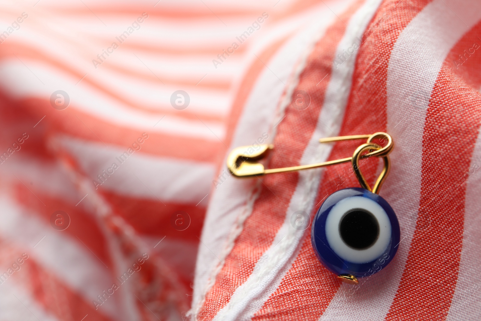 Photo of Evil eye safety pin on clothing, closeup