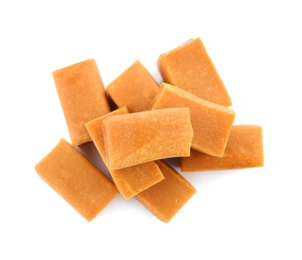 Delicious caramel candies on white background