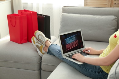 Photo of Woman using laptop with Black Friday announcement on screen, closeup
