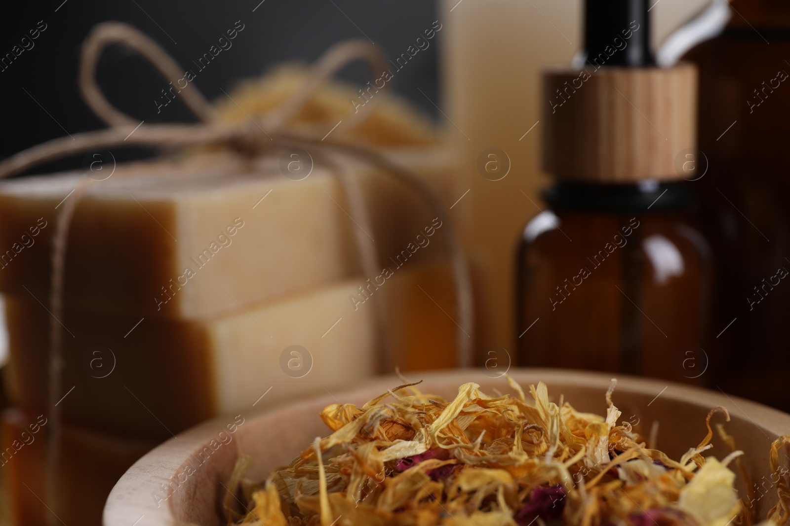 Photo of Spa composition. Dry flowers, bottle and soap bars on blurred background, closeup. Space for text