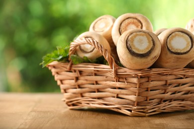 Photo of Wicker basket with delicious fresh ripe parsnips on wooden table outdoors