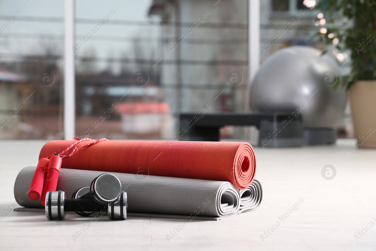Photo of Set of fitness equipment of floor indoors. Space for text