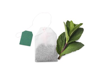 Photo of New tea bag with label and mint on white background, top view