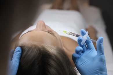 Photo of Beautiful woman getting facial injection in salon