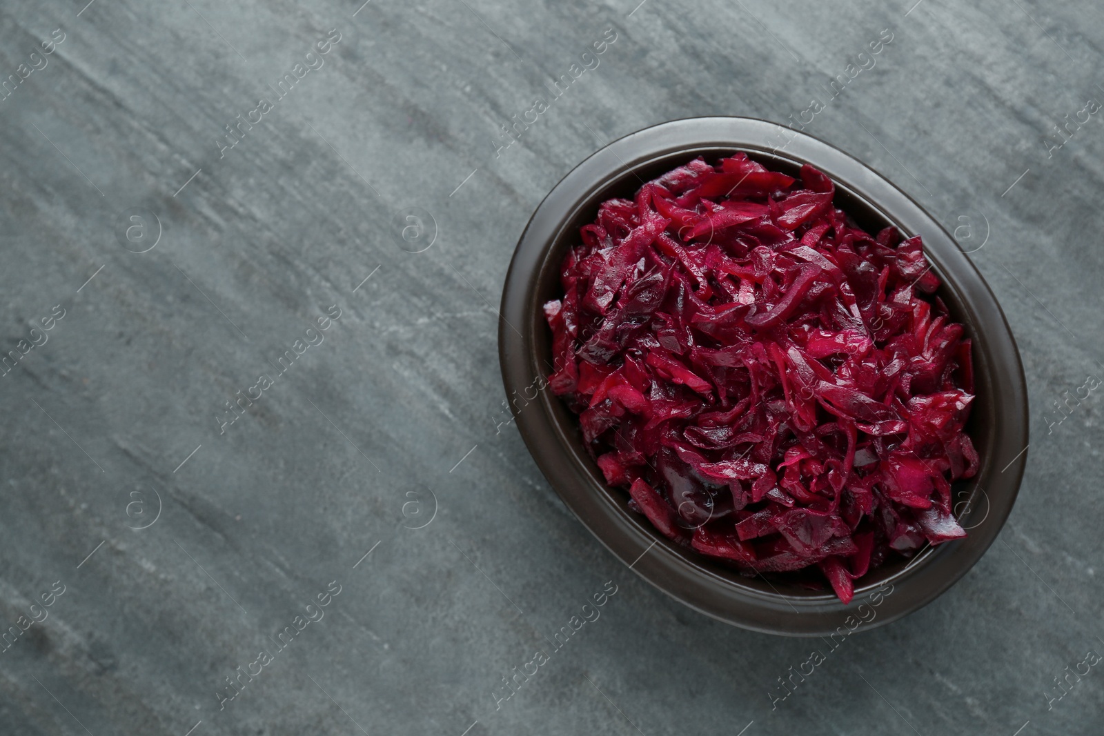 Photo of Tasty red cabbage sauerkraut on grey table, top view. Space for text