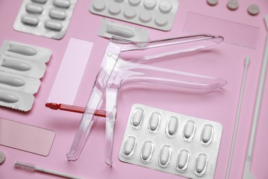 Photo of Sterile gynecological examination kit and medicaments on pink background