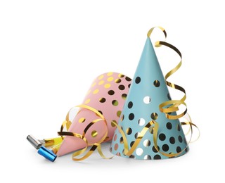 Colorful party hats, blowers and confetti streamers on white background