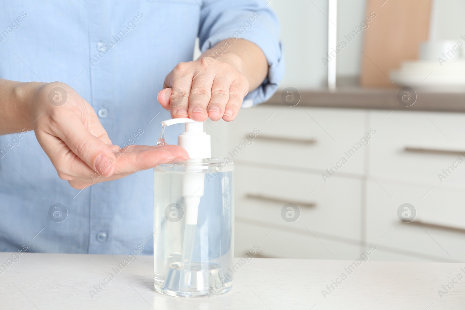 Photo of Woman applying antiseptic gel on hand indoors, closeup. Space for text