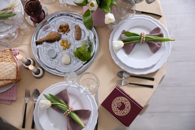 Photo of Festive Passover table setting with Torah, top view. Pesach celebration