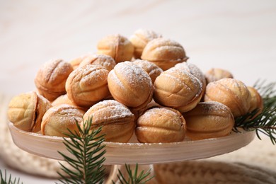 Delicious nut shaped cookies and fir tree branches on table, closeup