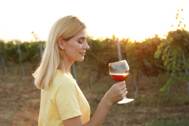 Photo of Young beautiful woman enjoying wine at vineyard on sunny day