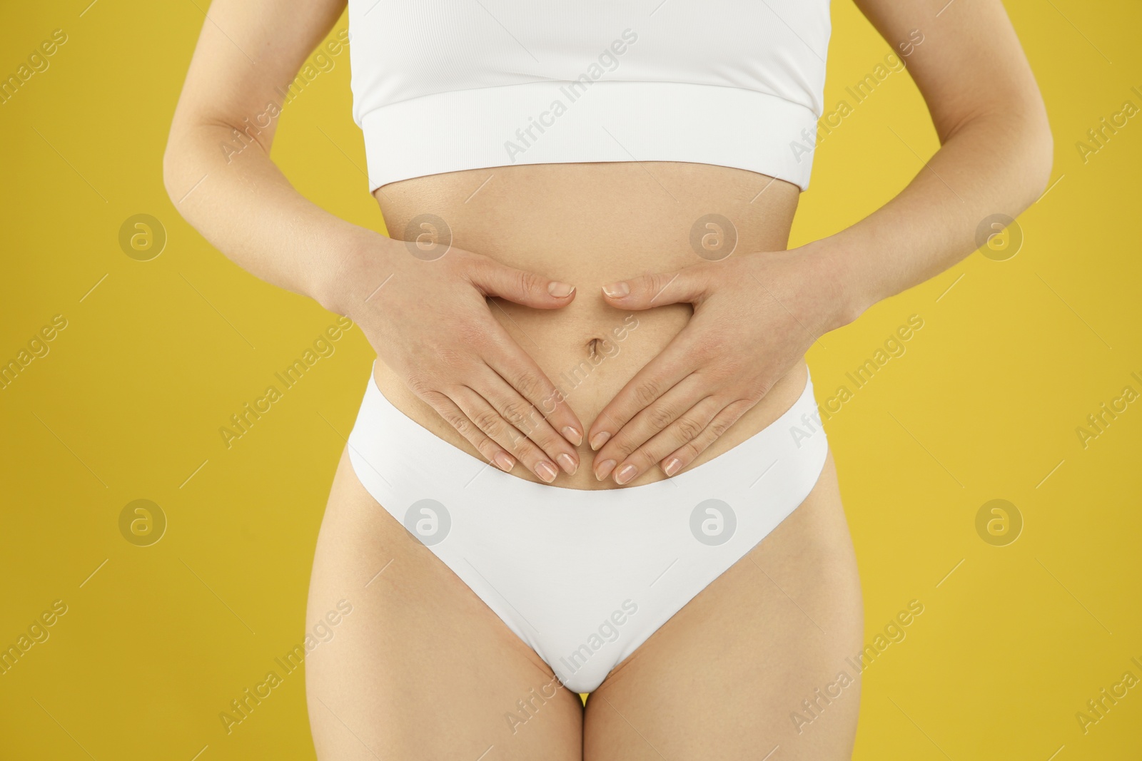 Photo of Gynecology. Woman in underwear on yellow background, closeup