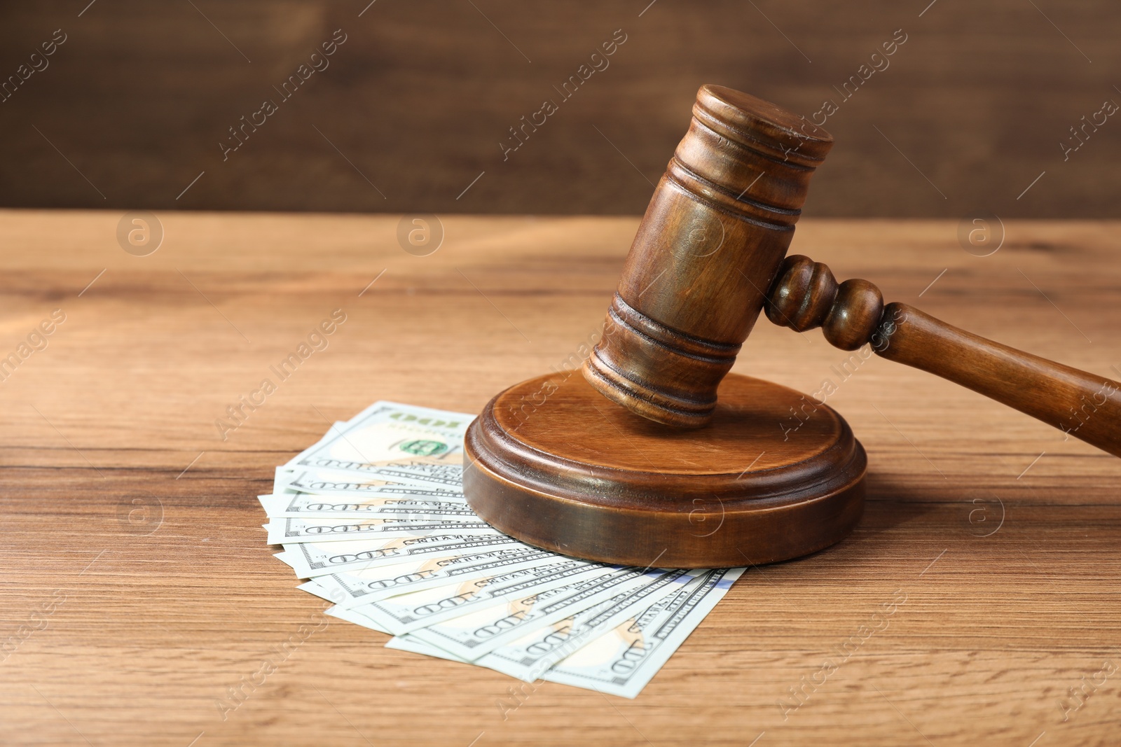 Photo of Judge's gavel and money on wooden table. Space for text